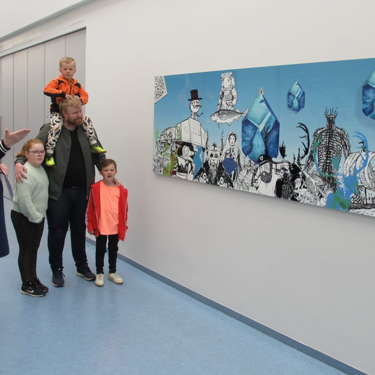 Listamaðurinn Odee afhendir Ástu Stefaníu skólastjóra verkið góða.